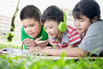 Three happy children resting in the park