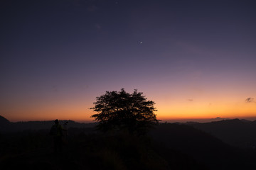 Fototapeta na wymiar Silhouette tree and moon at sunrise Kintamani Bali ,Indonesia.