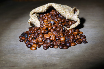 Coffee beans in sackcloth bag on wooden table