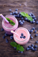 Healthy strawberry yogurt with mint and berries around on wooden background