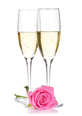 Two champagne glasses and pink rose flower