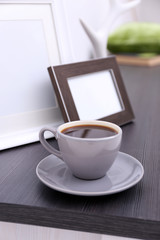 Fototapeta na wymiar Cup of coffee on commode in room