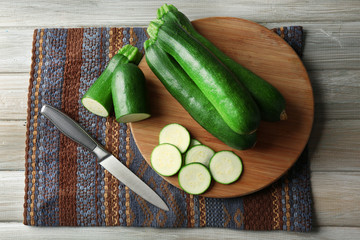 Fresh sliced zucchini on cutting board, on wooden background
