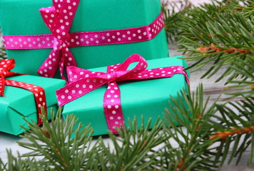 Wrapped gifts for Christmas and spruce branches on old plank