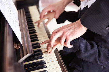 Fototapeta premium Close up of musician man and girl hands piano playing