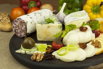 Salami with walnuts. Delicious specialty. Different kinds of cheese and vegetables. Healthy dairy products.
