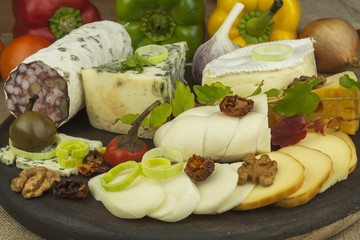 Salami with walnuts. Delicious specialty. Different kinds of cheese and vegetables. Healthy dairy products.
