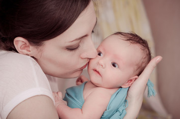 Mother kissing newborn baby