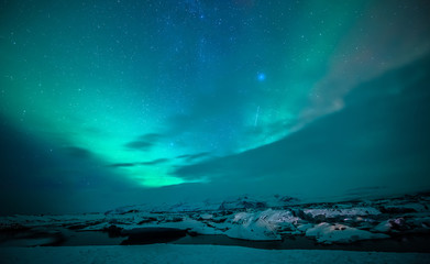 Fototapeta na wymiar auroral display over the glacier lagoon Jokulsarlon in Iceland.
