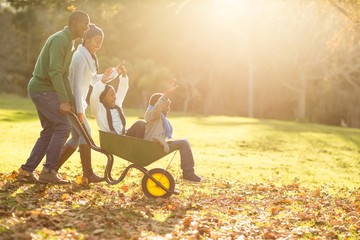 Young parents holding their children in a wheelbarrow