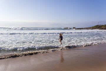 Girl preteen child walking jumping shoreline morning beach swim