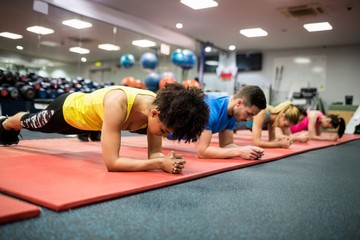 Fit people working out in fitness class - obrazy, fototapety, plakaty