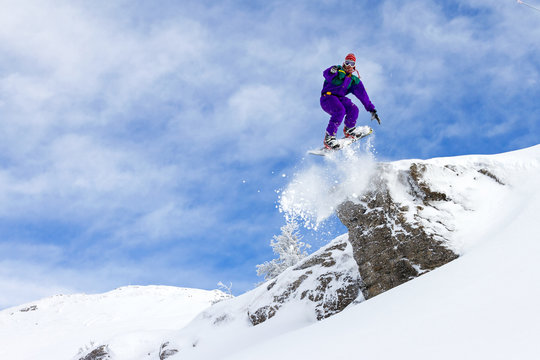 Awesome snowboarder jumps of a cliff in Les Portes du Soleil in France