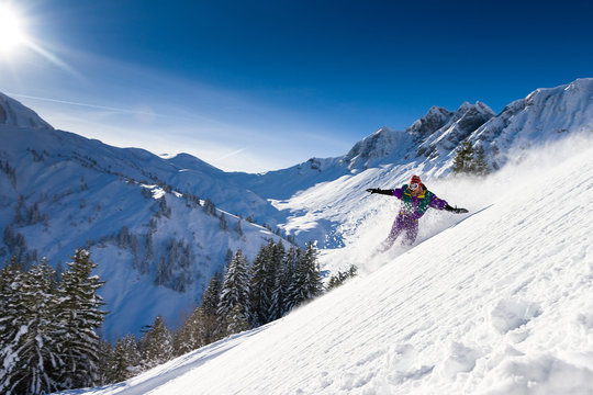 Awesome snowboarder is having fun in the backcountry powder of Les Portes du Soleil in France