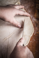 Womens hands in a process of preparing of dough for lagman. Tone