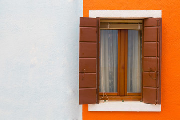 Orange-white wall and window close up, a house wall fragment on Burano's island, Venice
