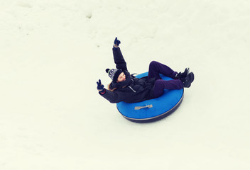 Fototapeta na wymiar happy young man sliding down on snow tube