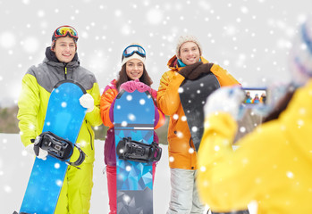 happy friends with snowboards and smartphone