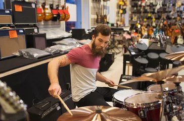 Deurstickers Muziekwinkel male musician playing cymbals at music store