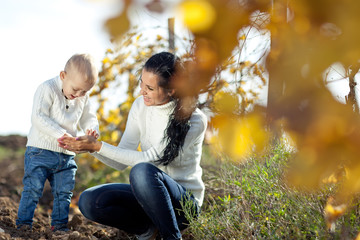 Happy mother with her son in a autumn nature