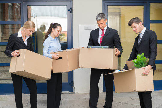 Unhappy Businesspeople With Cardboard Boxes Outside The Office