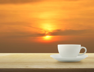 Obraz premium White cup on wooden table over sky