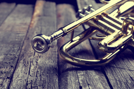 Trumpet on an old wooden table. Vintage style.