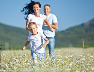 Happy family in a camomile field 