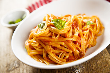Pasta with vegetable sauce and green basil