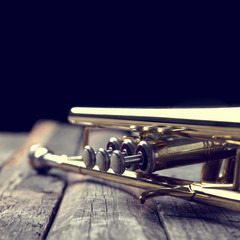 Obraz na płótnie Canvas Trumpet on an old wooden table. Vintage style.