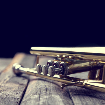 Trumpet on an old wooden table. Vintage style.