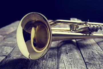 Trumpet on an old wooden table. Vintage style.