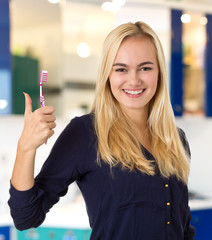 Attraktive junge Frau mit strahlend weißen Zähnen,  Zahnbürste