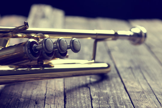 Trumpet on an old wooden table. Vintage style.