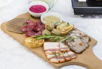 wooden dish with bacon and sausage on a white background
