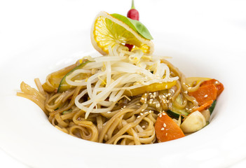 spaghetti with chicken and vegetables on a white background in the restaurant