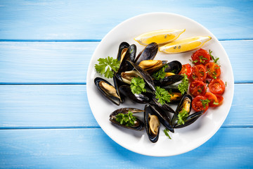 Cooked mussels with lemon and cherry tomatoes - obrazy, fototapety, plakaty