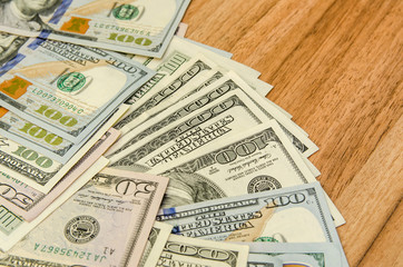 many dollar bills on wooden table