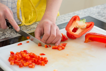 Köchin schneidet roten Paprika
