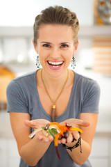 Woman holding in hand colorful halloween gummy worm candies.
