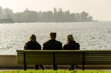 Rentner sitzen auf Bank mit Blick auf See