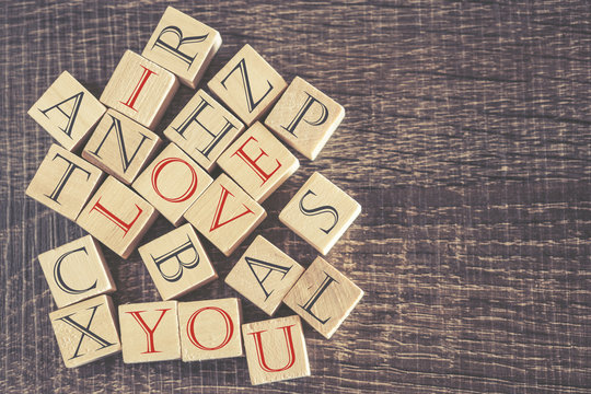 I Love You message formed with wooden blocks. Cross processed image for retro look