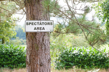 spectator viewing area sign on a pine tree