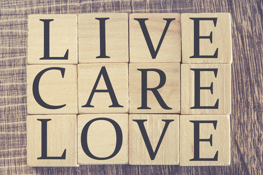 Live Care Love message formed with wooden blocks. Cross processed image for retro look