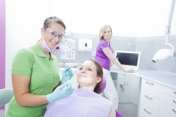 Obraz premium Female dentist starting to work on teeth of woman in a dentist r