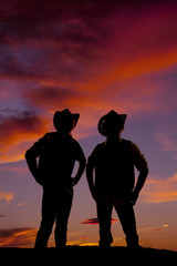 silhouette of two cowboys standing in the sunset