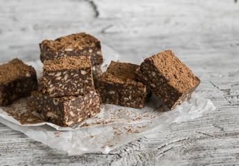 chocolate fudge with cookies and nuts on a light wooden surface