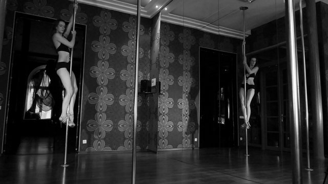 Sexual  stripper  girl training on  pole hall. Black & white .4K 3840x2160
