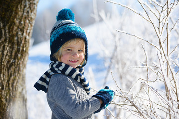 Cute  smiling  boy in winter hat in snow forest