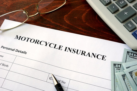 Motorcycle insurance  form and dollars on the table.